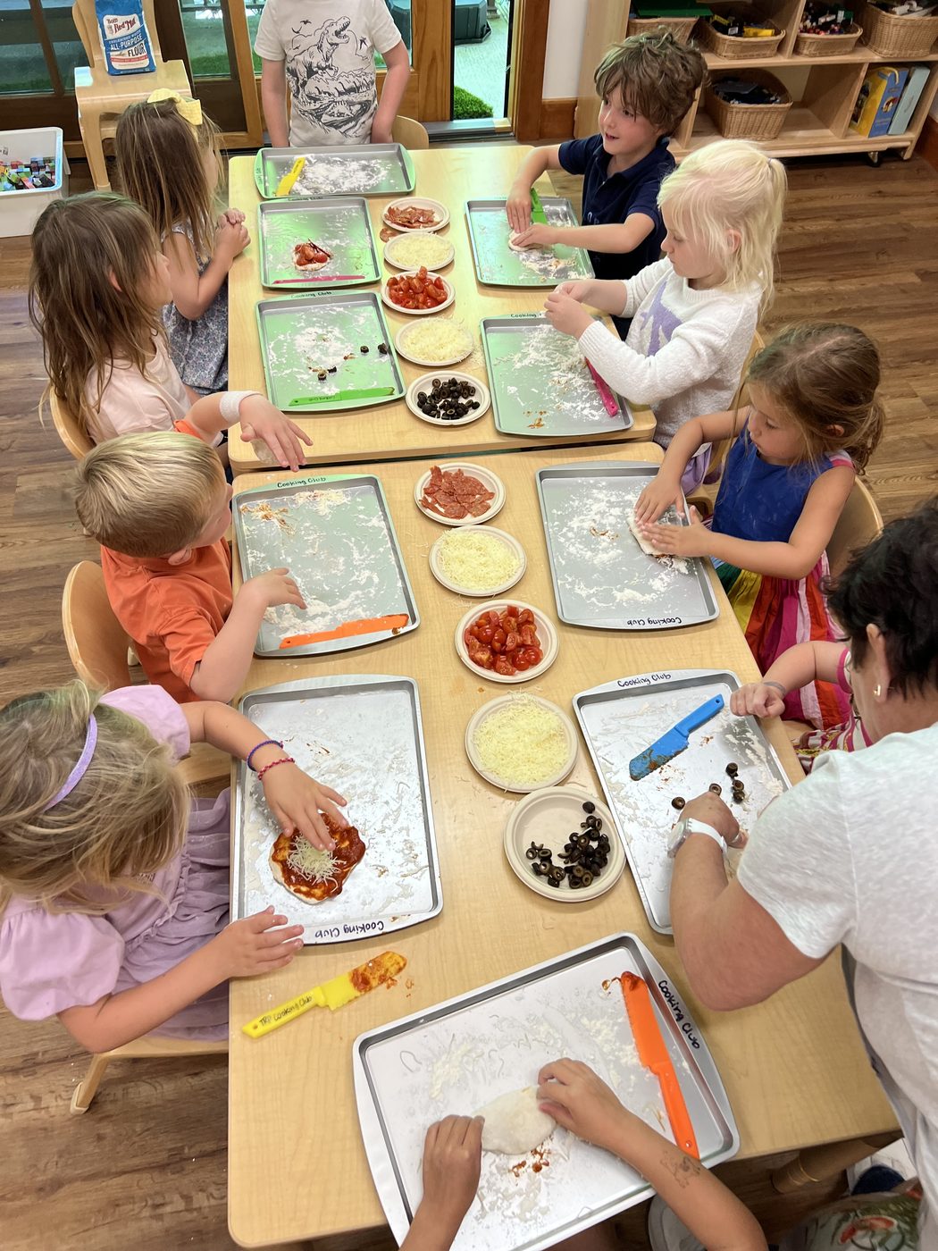 Children making pizza together at camp