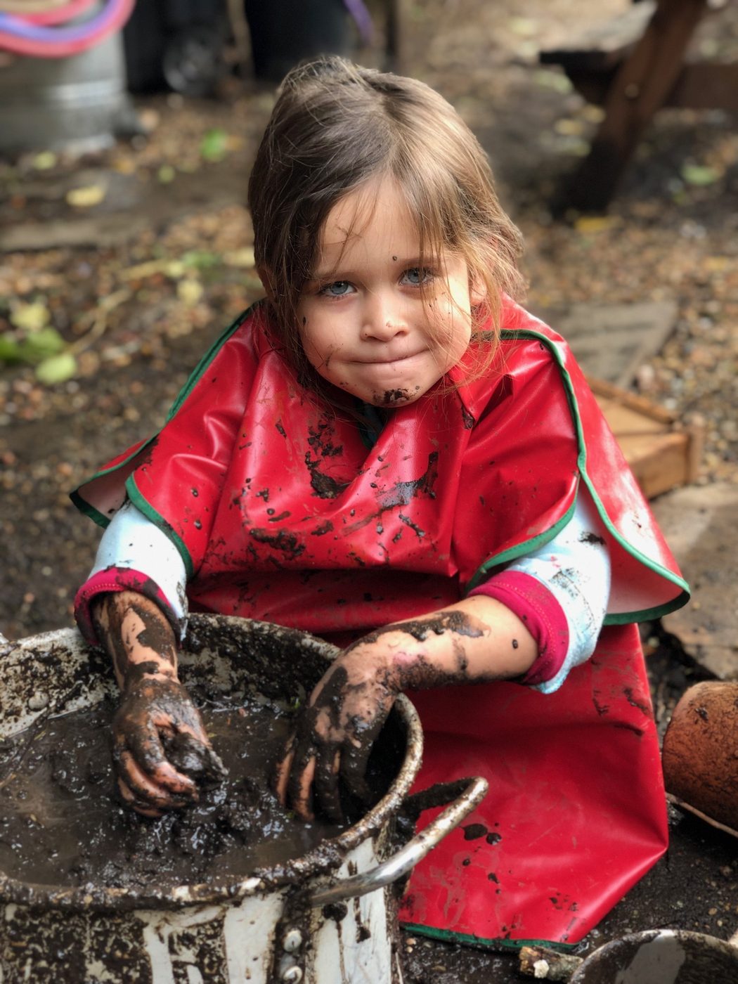 Child exploring mud at The Ross Preschool